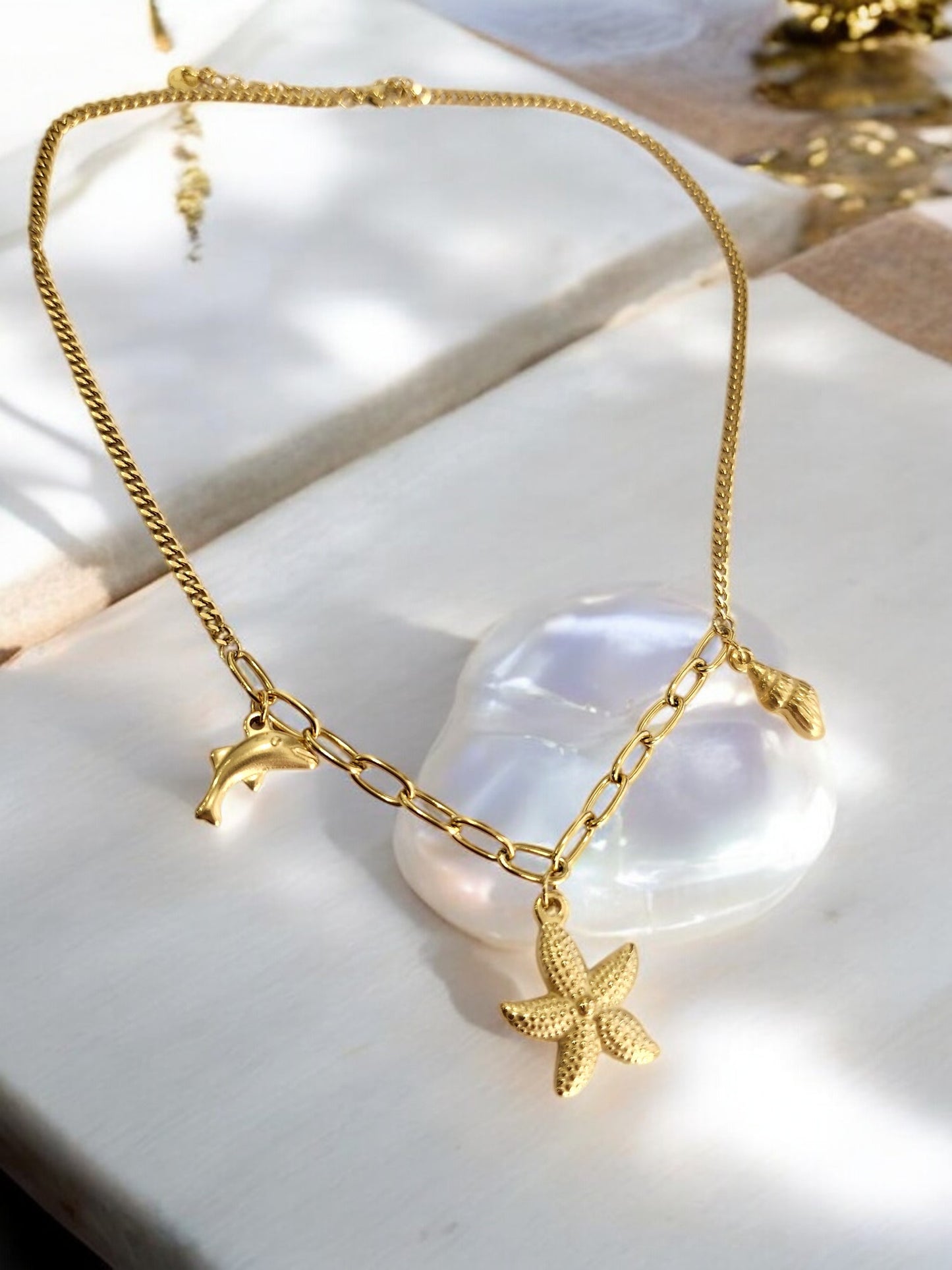 GOLDEN CHAIN WITH CHARMS LIKE DOLPHIN, STAR FISH AND TINY CONCH