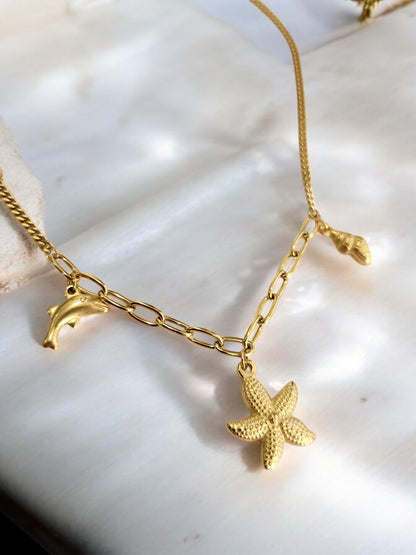 GOLDEN CHAIN WITH CHARMS LIKE DOLPHIN, STAR FISH AND TINY CONCH