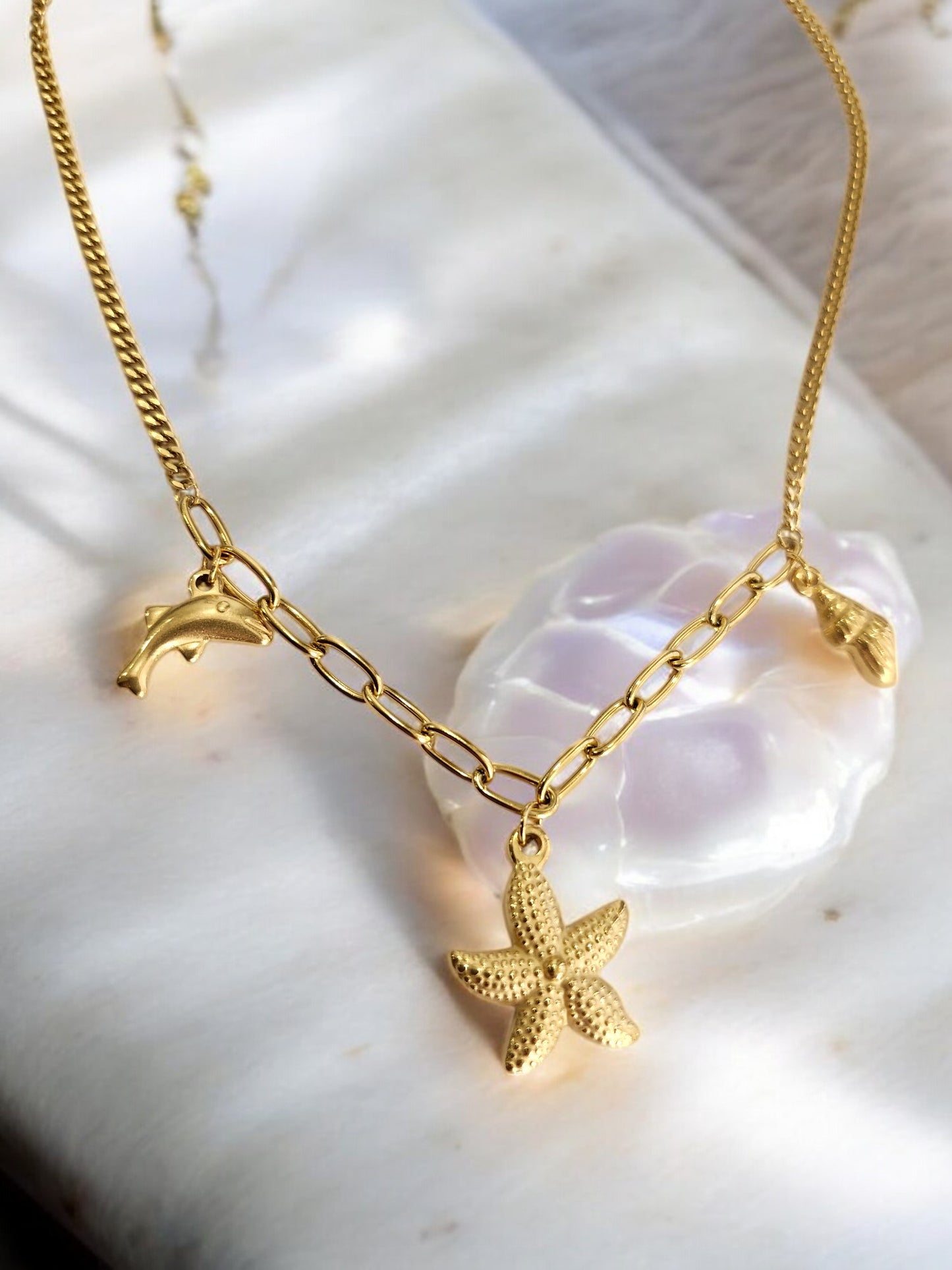 GOLDEN CHAIN WITH CHARMS LIKE DOLPHIN, STAR FISH AND TINY CONCH
