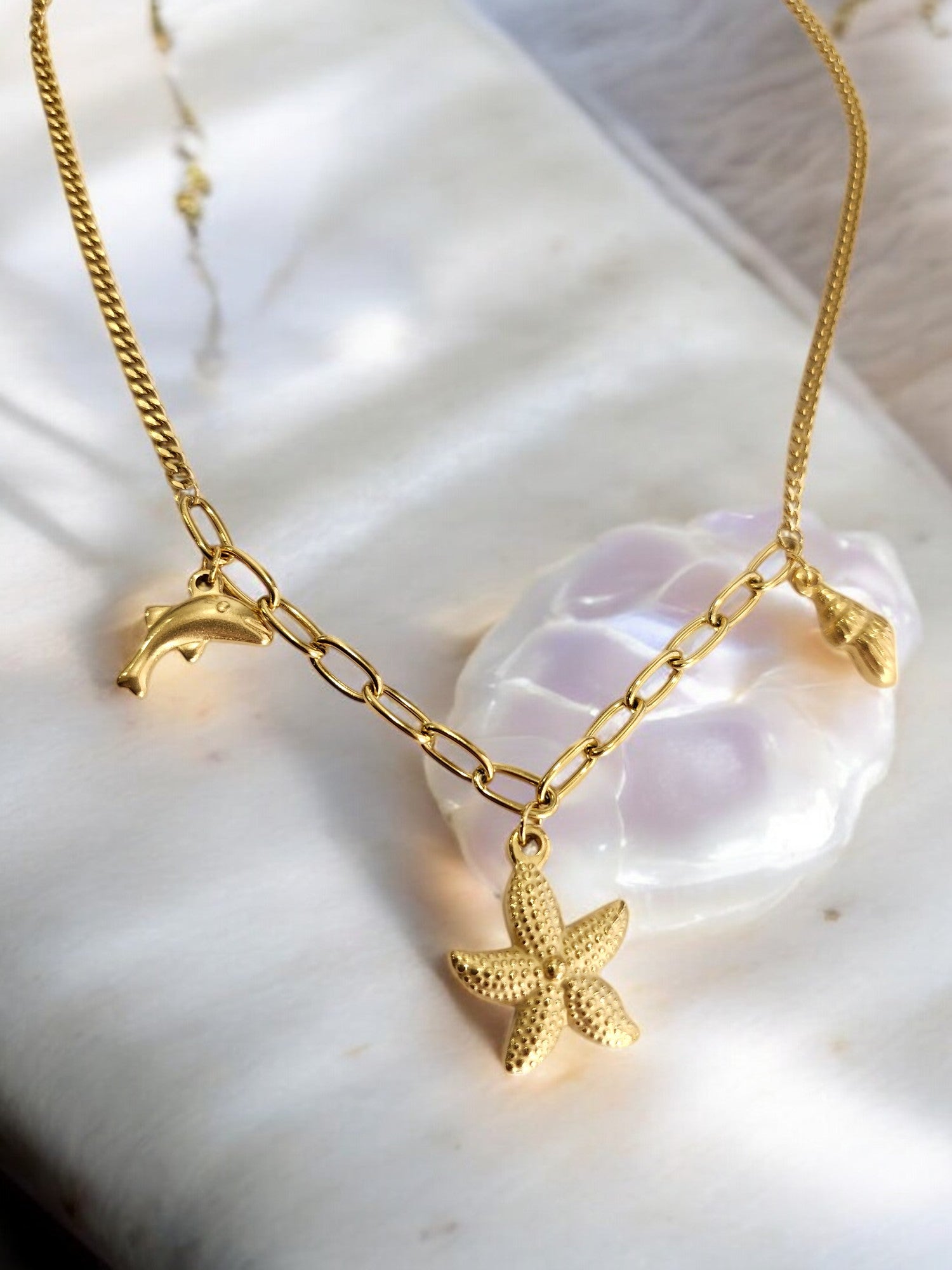 GOLDEN CHAIN WITH CHARMS LIKE DOLPHIN, STAR FISH AND TINY CONCH