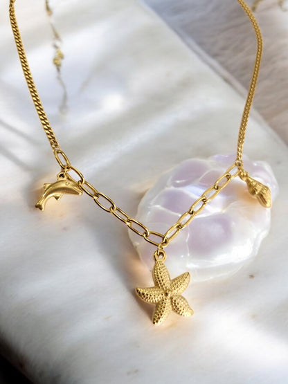 GOLDEN CHAIN WITH CHARMS LIKE DOLPHIN, STAR FISH AND TINY CONCH