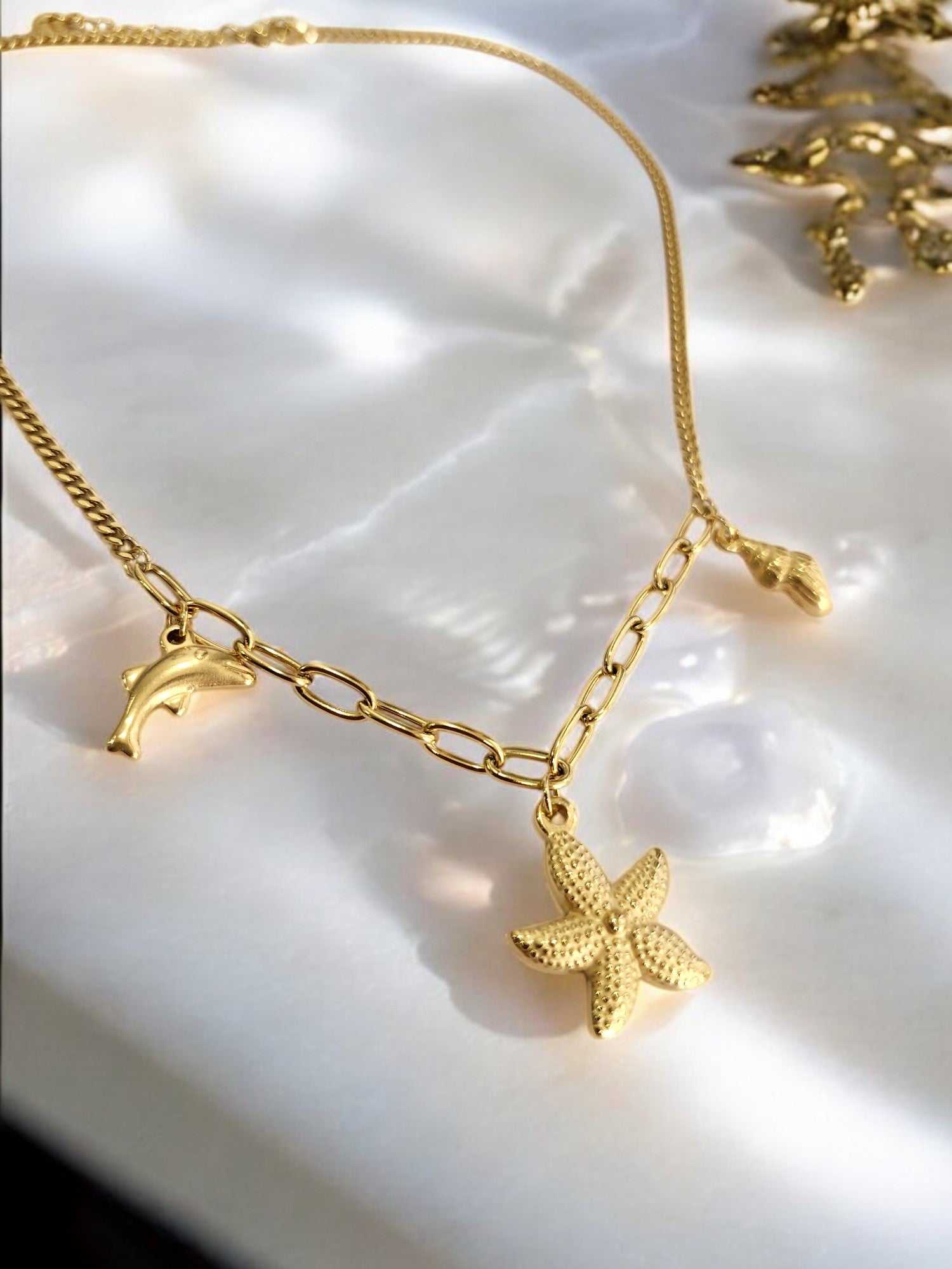 GOLDEN CHAIN WITH CHARMS LIKE DOLPHIN, STAR FISH AND TINY CONCH