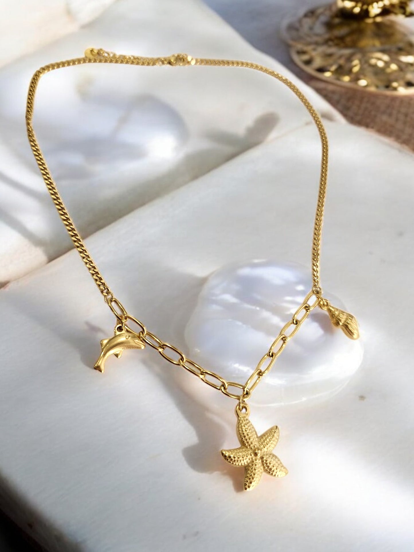 GOLDEN CHAIN WITH CHARMS LIKE DOLPHIN, STAR FISH AND TINY CONCH